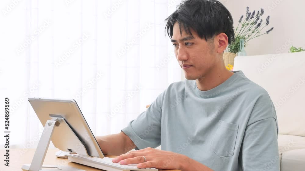 リビングでタブレットを使う男性 リビングでタブレットを使う男性