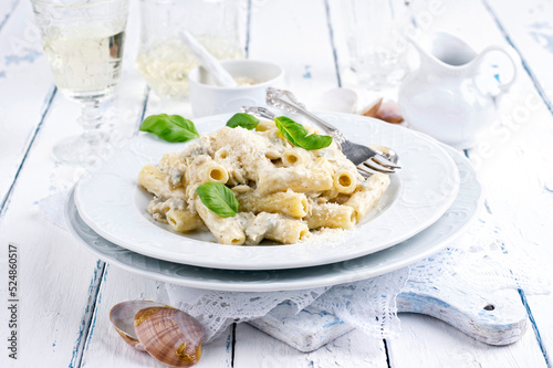 Traditional Italian pasta rigatoni al gorgonzola with vongole and cheese served as close-up on a classic design plate