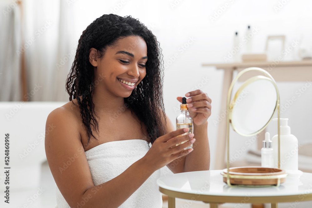 Happy Black Lady Holding Bottle With Moisturising Serum For Skincare Happy Black Lady Holding Bottle With Moisturising Serum For Skincare