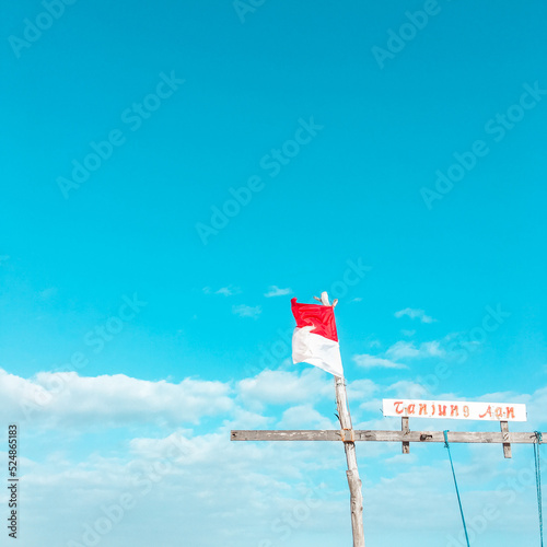 Mandalika, West Nusa Tenggara, Indonesia-August, 2019 : Indoesia red-white flag fluttered over the blue sky photo