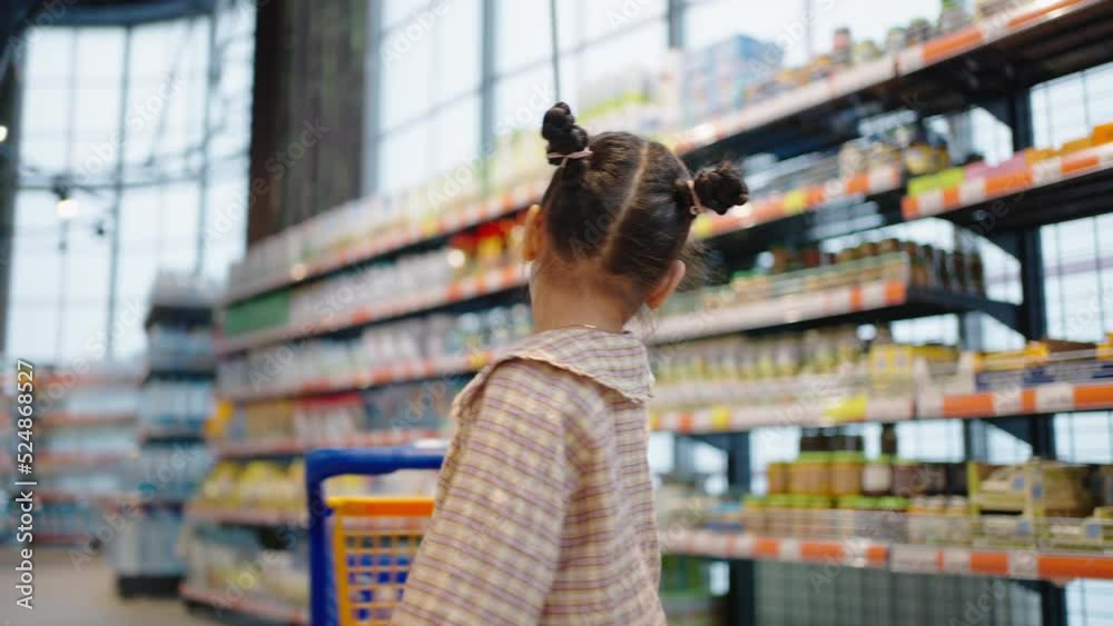 Preschooler girl spins with shopping cart in supermarket Preschooler girl spins with shopping cart in supermarket