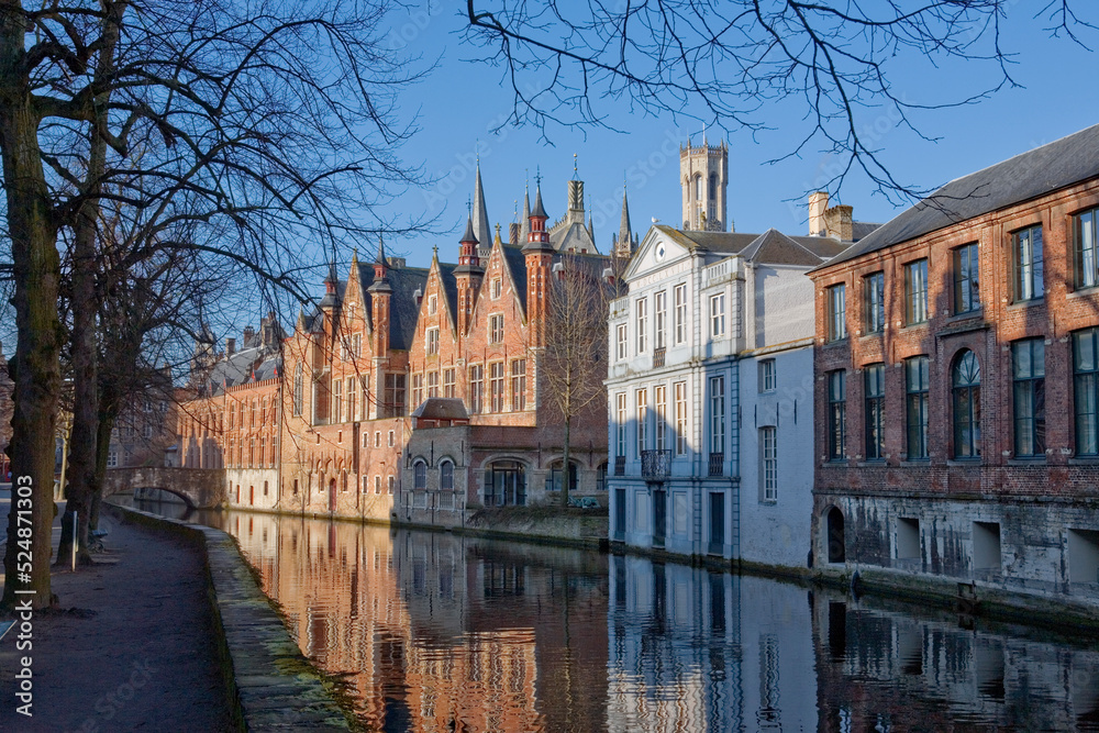 View along the Groenerei canal from Steenhouwersdijk, Brugge, Belgium, towards the city centre, showing the Palace of the Liberty of Bruges (Het Brugse Vrije) and a baroque mansion, Huize De Caese
