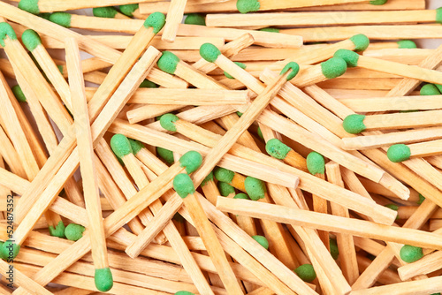Background of randomly scattered matches with green heads