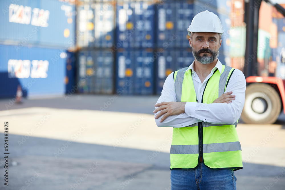 portrait factory worker or engineer folded arms pose in containers warehouse storage