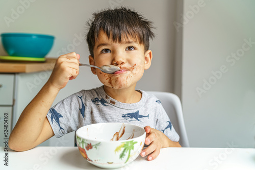little boy eats his favorite food beaming with joy