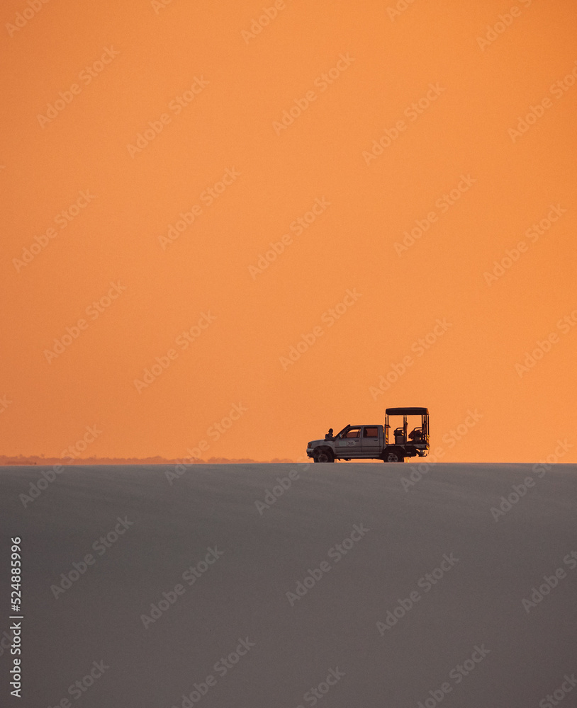 Fototapeta premium silhouette of an offroad car in the desert at sunset