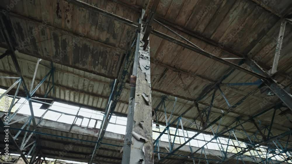 Burned roof of abandoned and demolished industrial warehouse inside. Critical infrastructure damaged by russian troops in Ukraine during cruel war. Russian-Ukrainian war Burned roof of abandoned and demolished industrial warehouse inside. Critical infrastructure damaged by russian troops in Ukraine during cruel war. Russian-Ukrainian war
