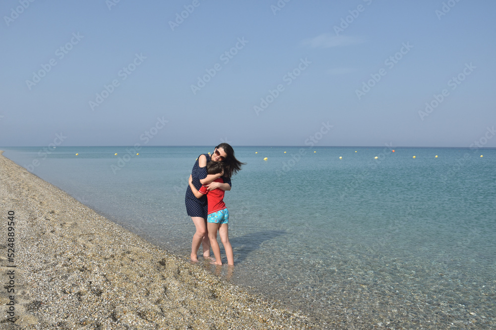 Mother and little boy on the beach. Mom and child hugging and enjoy by the sea