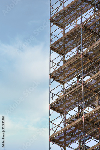 Abstrakte Nahaufnahme eines Gerüsts beim Hausbau oder bei einer Renovierung einer Hauswand - Seitlich Fotografiert (Halb Gerüst / halb Wolken)