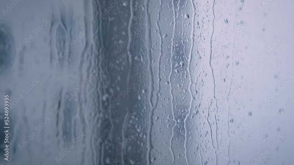 Close-up of water droplets on glass, Rain Rain, Go Away. Large rain drops strike a window pane during a summer shower. at apartment view with other building around. 4K. Close-up of water droplets on glass, Rain Rain, Go Away. Large rain drops strike a window pane during a summer shower. at apartment view with other building around. 4K.