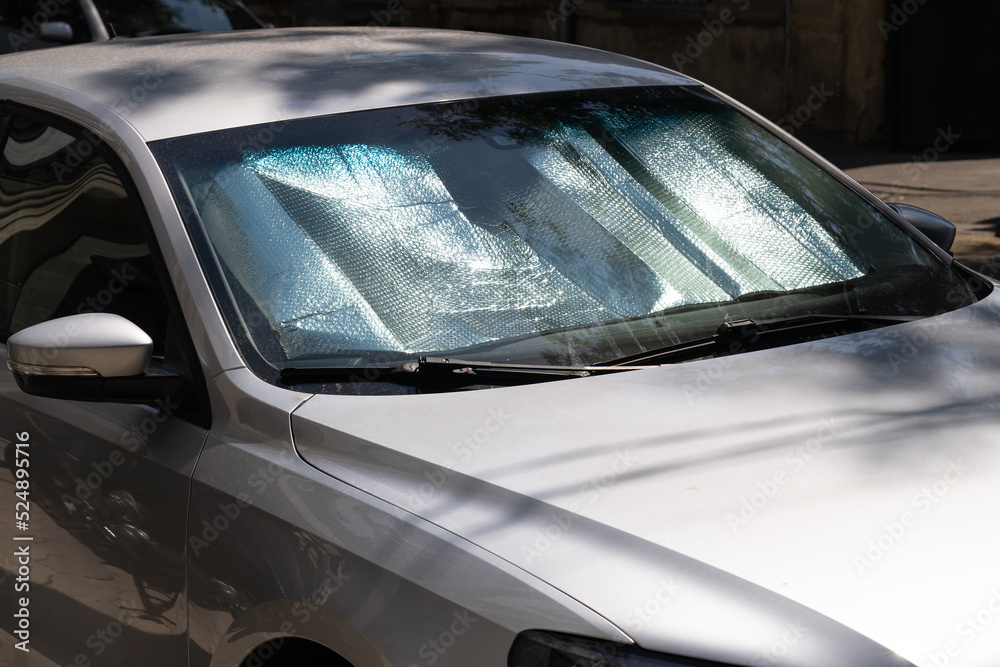 Closeup of protective reflective surface under the windshield of the passenger car parked on a hot day, heated by the sun's rays inside car. Sunshade, Heat protection, auto accessory concept