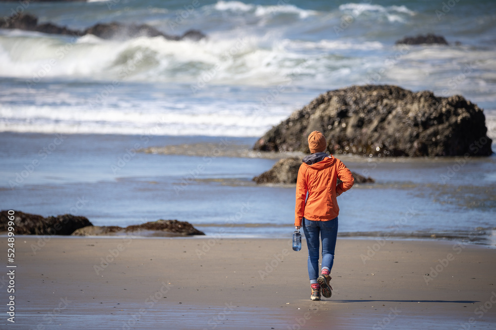 Girl walks along the rocky shore of the oregon coast near Bandon, OR