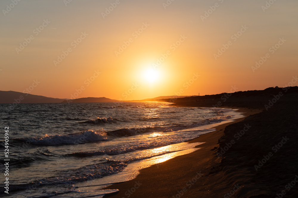 Sunset with sea and sun path over the water and beach