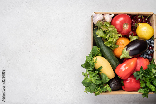 Fresh vegetables and fruits in cardboard box on white background. The concept of food delivery, farm organic products