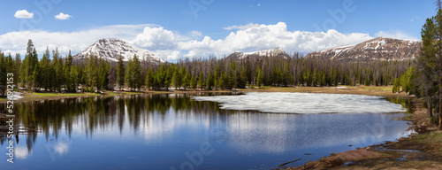 Lake surrounded by Mountains and Trees in Amercian Landscape. Spring Season. Lilly Lake in Uinta-Wasatch-Cache National Forest, Utah. United States. Nature Background Panorama