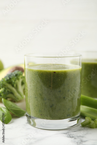 Delicious fresh green juice on white marble table, closeup