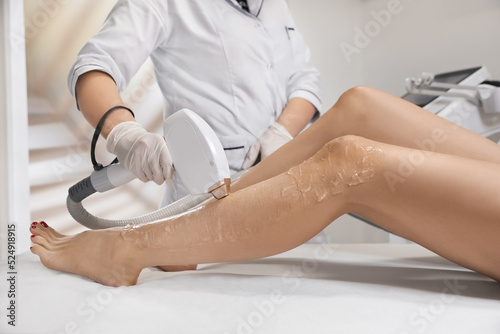 Woman undergoing laser epilation procedure in beauty salon, closeup
