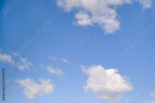 White cumulus clouds in the blue sky. Bright beautiful sky, copy space background