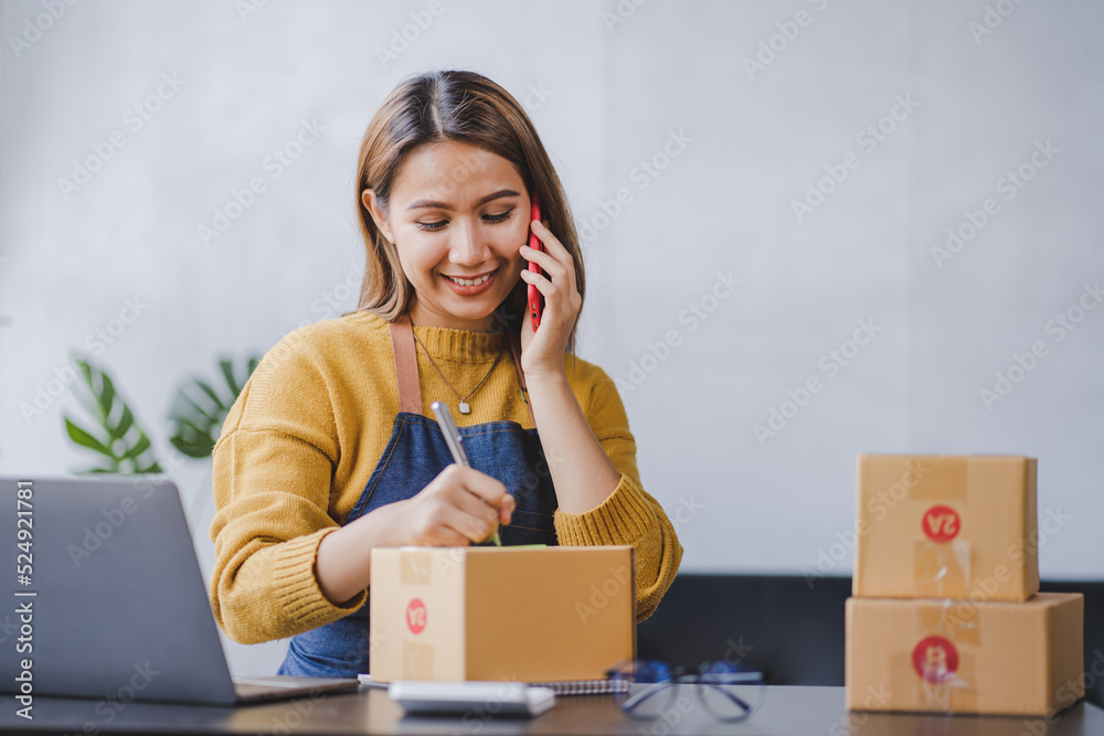 Portrait of a small business startup, SME owner, female entrepreneur, working, unboxing, checking orders online. To prepare to pack boxes for sale to SME customers online business ideas Portrait of a small business startup, SME owner, female entrepreneur, working, unboxing, checking orders online. To prepare to pack boxes for sale to SME customers online business ideas