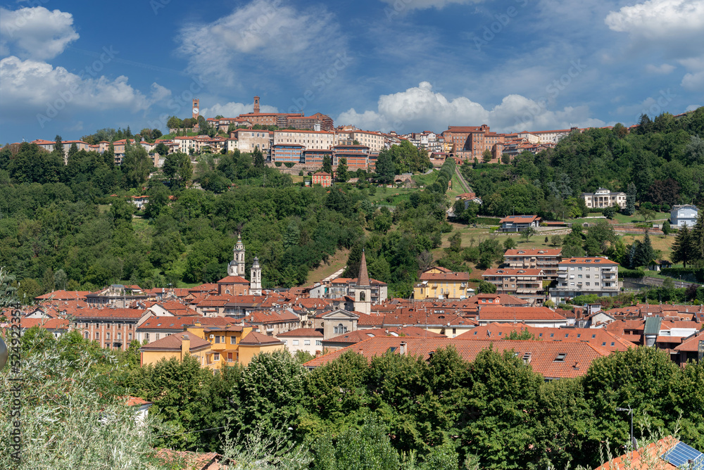 Mondovì, Cuneo, Italy: cityscape with below the Breo district and on the Mondovì hill Piazza with the clock tower and green parks with blue sky with white clouds