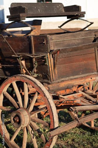 This is closeup, digitally enhanced image of a buckboard wagon originally from the Oregon ghost town, Shaniko.  Evening sunlight accentuates the oranges and browns of the weathered surfaces. photo