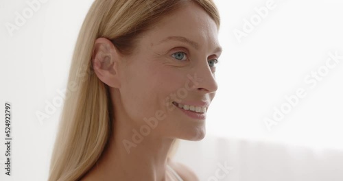 Beautiful gorgeous 50s mid aged mature woman looking at camera at bedroom