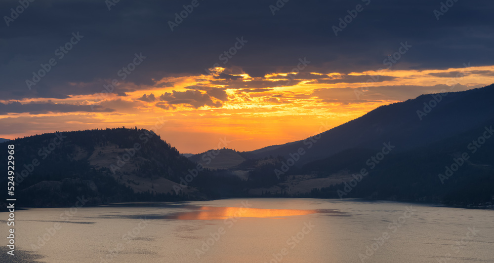 Dramatic Cloudy Sunrise in the desert landscape with mountains by the lake. Vernon, Okanagan, British Columbia, Canada. Canadian Nature Background.