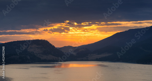 Dramatic Cloudy Sunrise in the desert landscape with mountains by the lake. Vernon, Okanagan, British Columbia, Canada. Canadian Nature Background.
