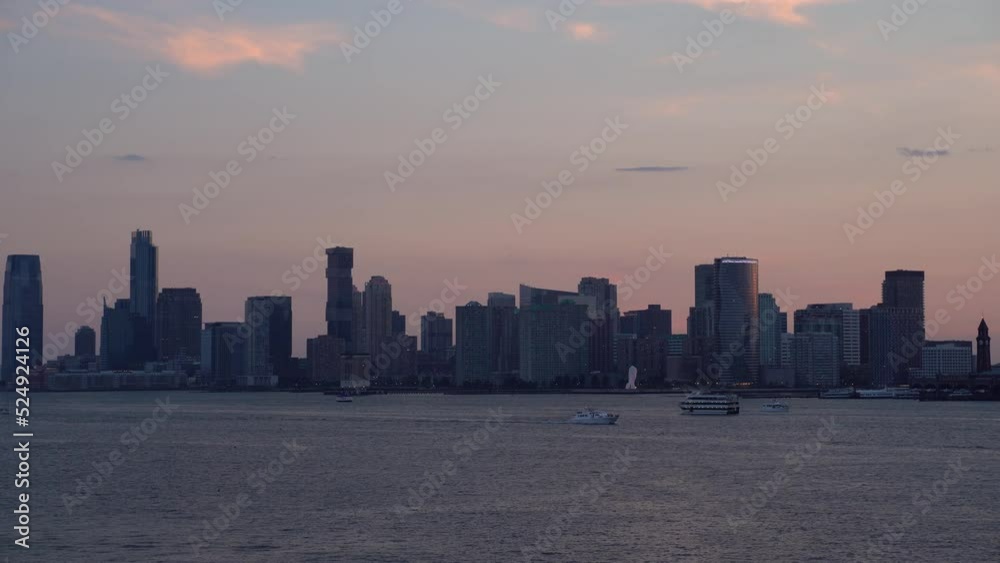 Sunset over Hudson river with ferry and ships, New Jersey sky line on background