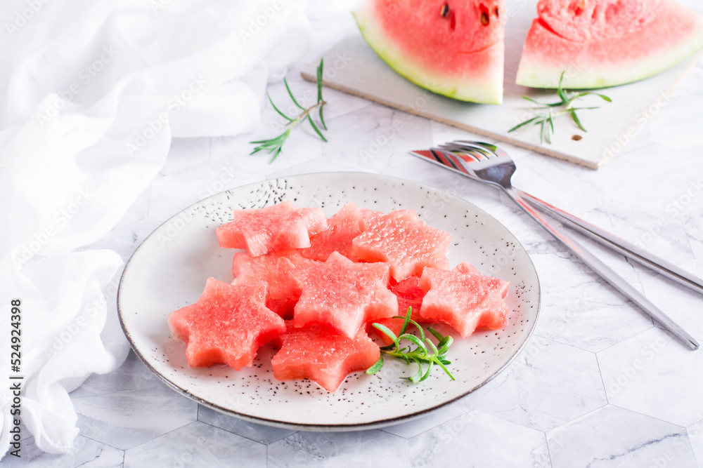 Ripe watermelon stars on a plate on the table. Summer refreshment.