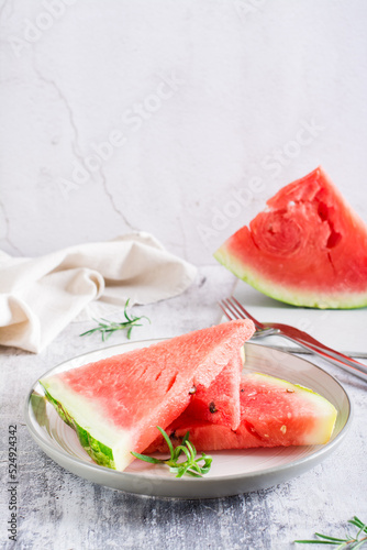 Pieces of ripe watermelon on a plate on the table. Summer refreshment. Vertical view