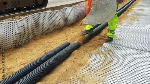 Groundworkers installing new electric ducts during roadworks photo