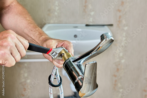 Repair work in bathroom, plumber installing new tap in home water supply system.