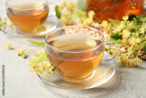 Tasty tea and linden blossom on light grey table