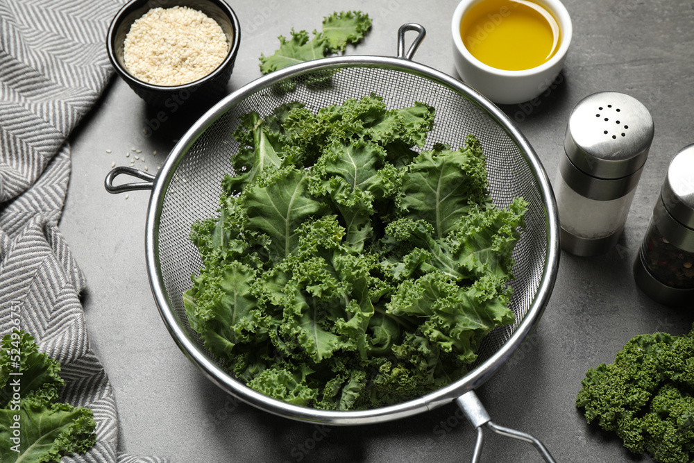 Raw cabbage leaves on grey table. Preparing kale chips Raw cabbage leaves on grey table. Preparing kale chips