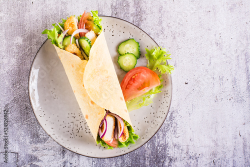 Billede på lærred Mexican tortilla wraps with  vegetables and chicken on a plate on the table