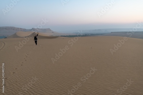 A female running on the top of a sand hill in Fayoum - Egypt. 