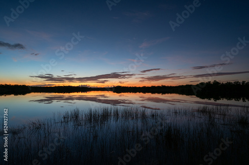 Colorful summer sunrise cloudscape over Nine Mile Pond reflected in perfectly calm water in Everglades National Park  Florida.