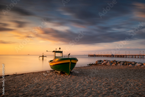 Baltic see, surise over beach and boat. Kuter rybacki na plaży w Gdyni Orłowo o wschodzie słońca nad morzem bałtyckim z widokiem na plażę i molo