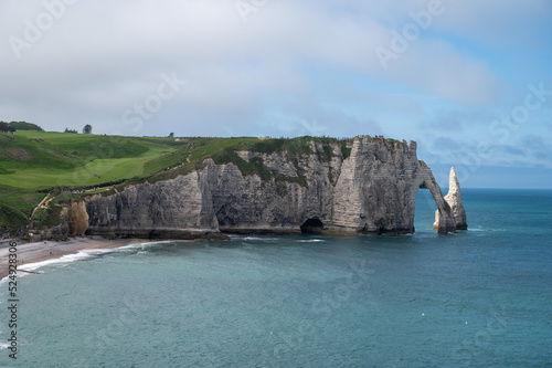 Panoramic view on chalk cliffs and Porte d'Aval arch in Etretat, Normandy, France. Tourists destination.