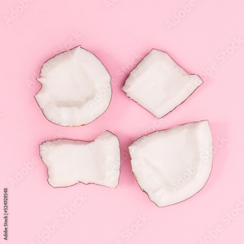 Sliced fresh coconut on pastel pink background. Flat lay