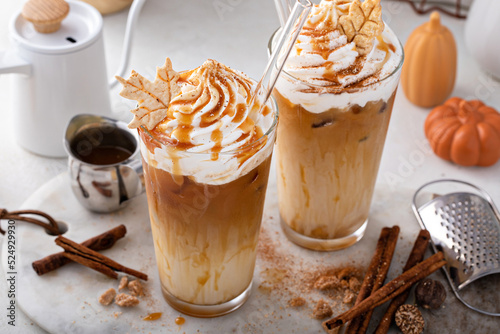 Fototapeta Naklejka Na Ścianę i Meble -  Iced pumpkin spice latte in tall glasses topped with whipped cream