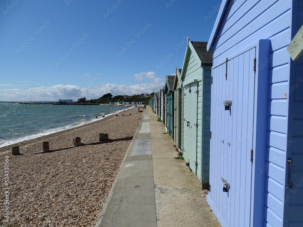 multicolored beach huts in lee on solent, on the shore, shingle beach