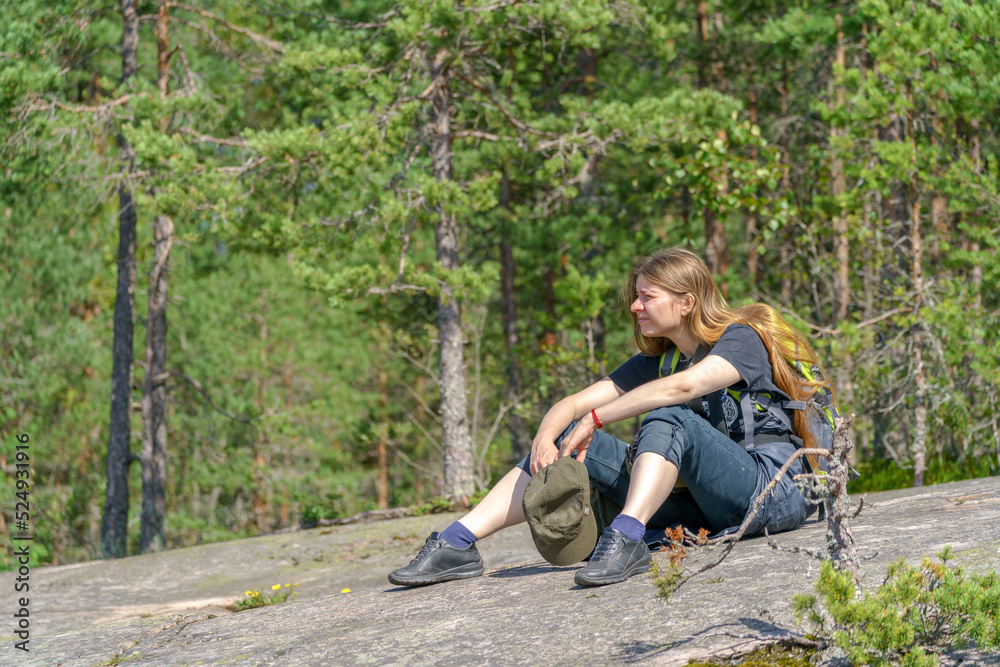 Girl tourist with a backpack sits on the shore