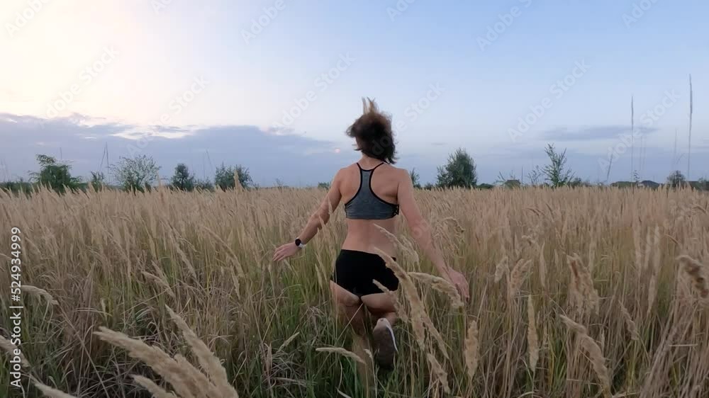 A beautiful girl in short shorts and a top runs across the field. Slow motion. A beautiful girl in short shorts and a top runs across the field. Slow motion.