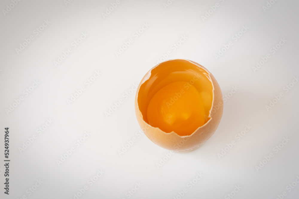 Cracked egg yolk on white table