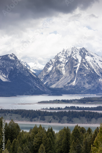 Lake surrounded by Trees and Mountains in American Landscape. Spring Season. Jackson Lake  Grand Teton National Park. Wyoming  United States. Nature Background.