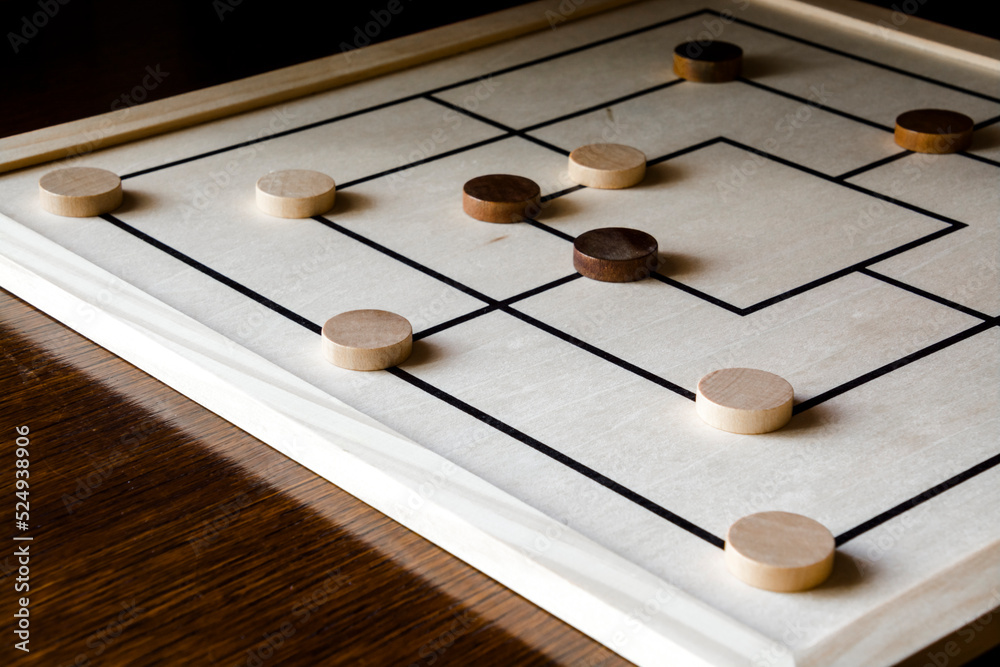 Playing mill game on a wooden table Playing mill game on a wooden table