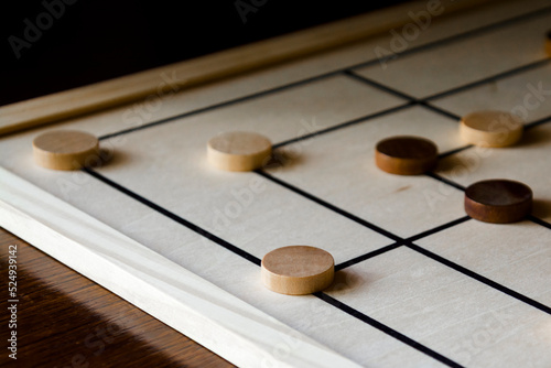 Playing mill game on a wooden table