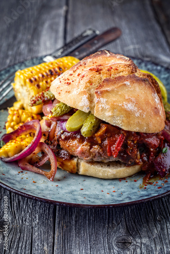 Traditional barbecue Mexican Hamburger served with vegetable and chili relish as close-up on a design plate